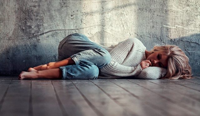 девушка лежит на полу у стены