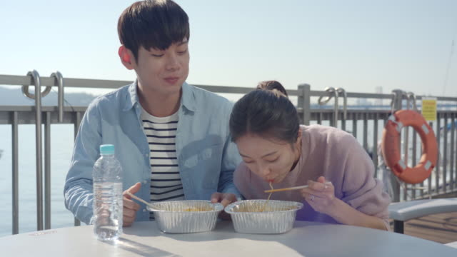 корейская пара ест рамен за столом