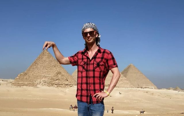 парень в очках на фоне пирамиды хеопса