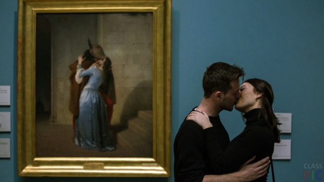 пара целуется перед картиной