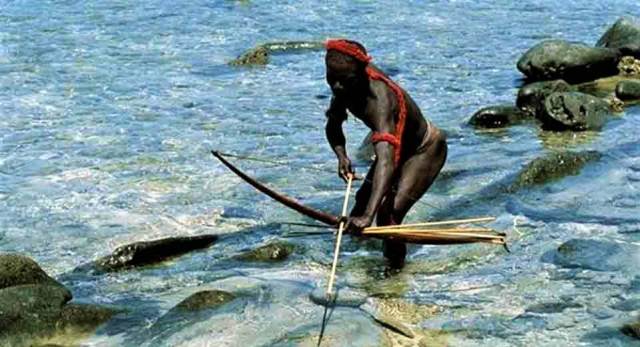 абориген с луком и стрелой в воде