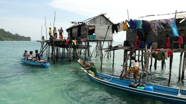 люди на лодках возле домов в воде