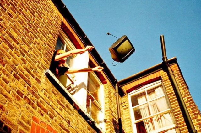человек выбрасывает телевизор в окно
