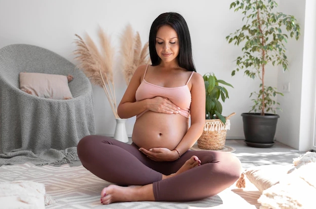 беременная женщина сидит на полу