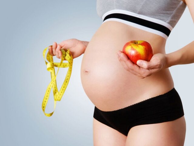 беременная с яблоком в руке