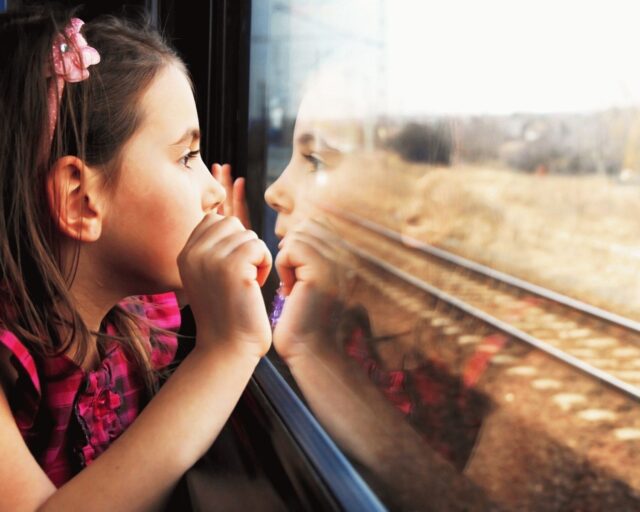 девочка смотрит из окна поезда