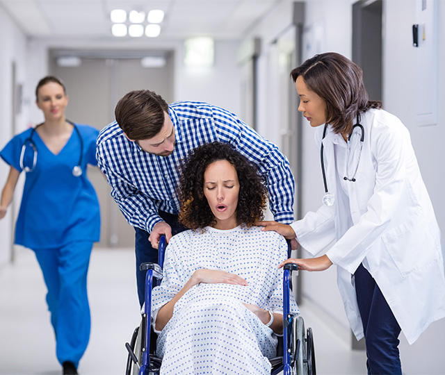 беременная женщина на каталке в окружении врачей