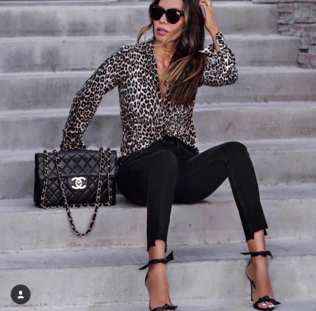 брюнетка в леопардовой блузке и черных брюках
