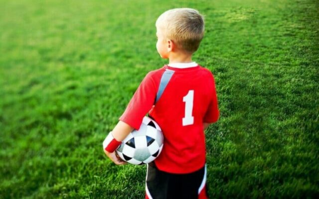 мальчик с футбольным мячом на поле