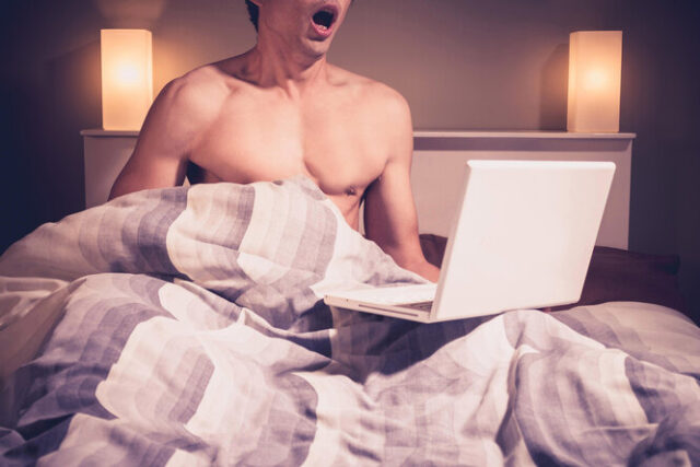 мужчина с ноутбуком в кровати