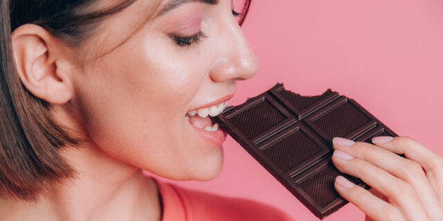 девушка кусает плитку шоколада