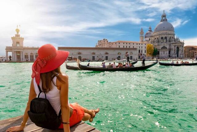 девушка сидит на берегу гранд канала в венеции