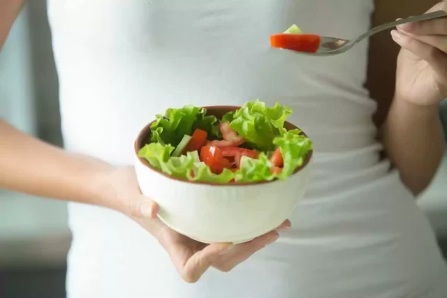 тарелка с салатом в женских руках